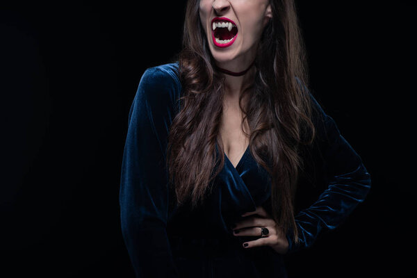 cropped view of woman showing vampire teeth isolated on black