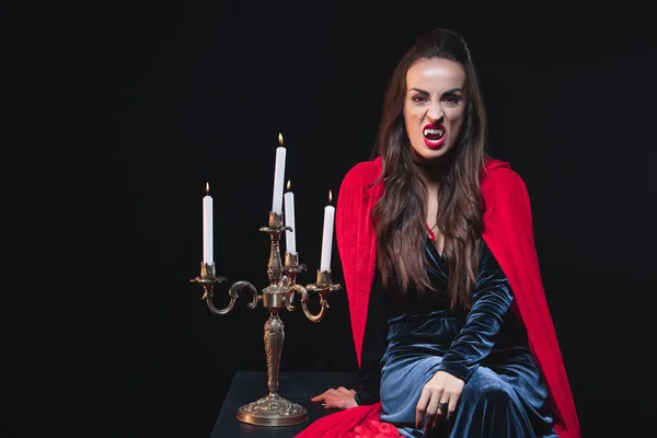 Sexy Mujer Traje Vampiro Sentado Cerca Vintage Candelabro Aislado Negro — Foto de stock gratis