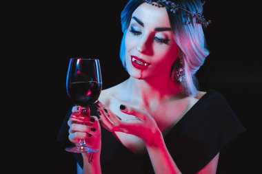 siyah izole kan ile bardağı tutan seksi vampir kadın
