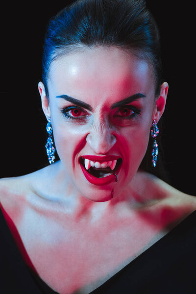 мрачный вампир смотрит на камеру, изолированную на черном
