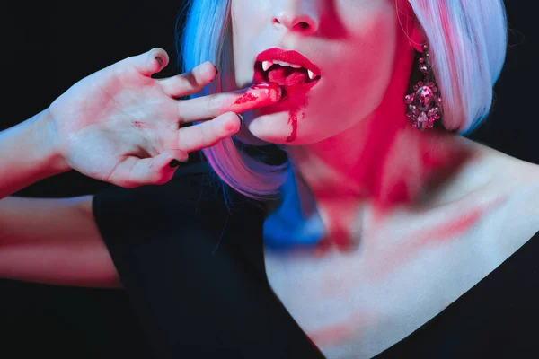 被裁剪的看法吸血鬼妇女舔血液从被隔绝的手指在黑 — 免费的图库照片
