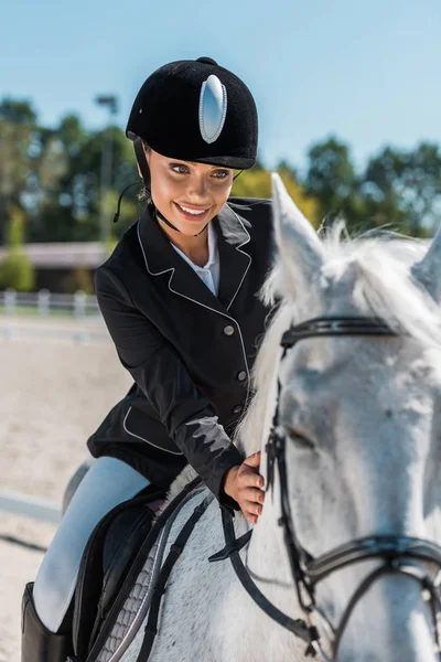 乗馬クラブで馬に乗ってプロのアパレルで魅力的な女性騎手の笑顔 — ストック写真