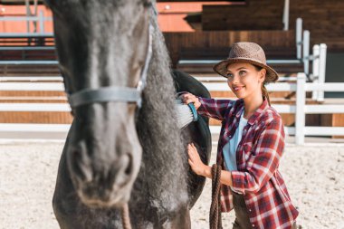 çekici cowgirl siyah at çiftliği nde fırça ile Temizleme