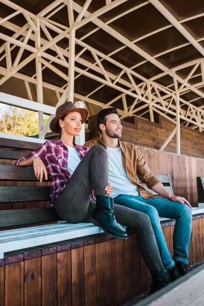 牛仔和女牛仔坐在牧场体育场的长凳上 看着远处 — 免费的图库照片