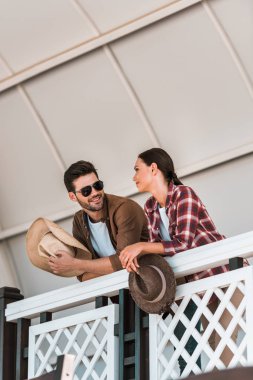 man and woman leaning on tribune railing and looking at each other at ranch stadium clipart