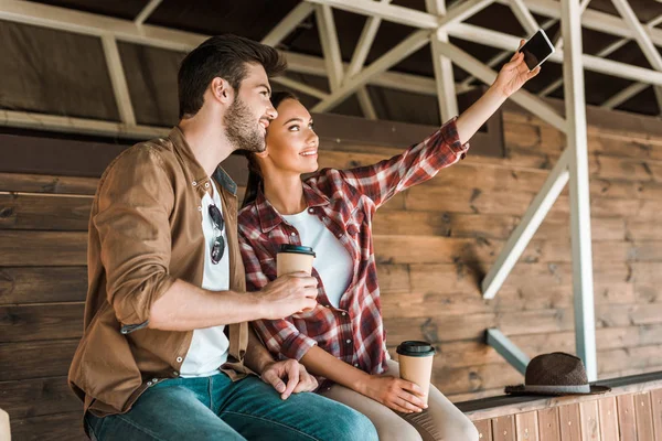 Colegas Sonrientes Tomando Selfie Con Teléfono Inteligente Sosteniendo Café Tazas — Foto de stock gratis