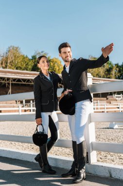 yakışıklı Binicilik meslektaşım Ranch'te bir şeye işaret eden profesyonel giyim
