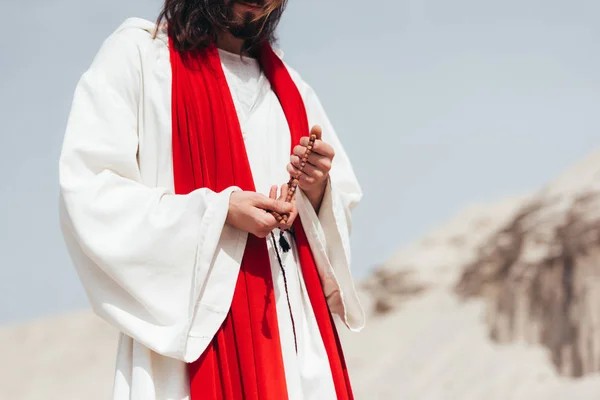 Кадроване Зображення Ісуса Холдингу Дерев Яні Розарій Молитися Пустелі — стокове фото