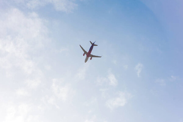low angle view of plane flying in blue cloudy sky