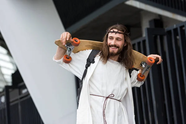 Lav Vinkel Smilende Jesus Morgenkåpe Tornekrone Som Holder Skateboard Skuldre – stockfoto