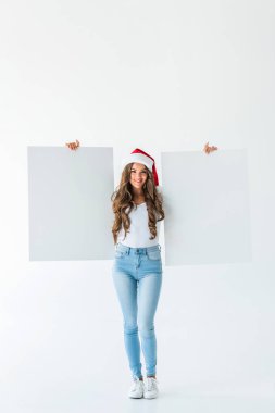 Noel Baba şapkası boş panoları, üzerinde beyaz izole tutan güzel genç kadın
