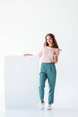 boş tahta ile duran ve üzerinde beyaz izole, başparmak gösterilen güzel ve genç birbayan