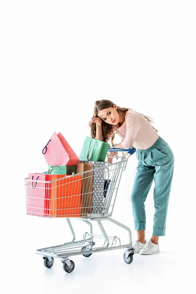 Schöne Müde Mädchen Mit Einkaufswagen Und Taschen Isoliert Auf Weiß — Stockfoto