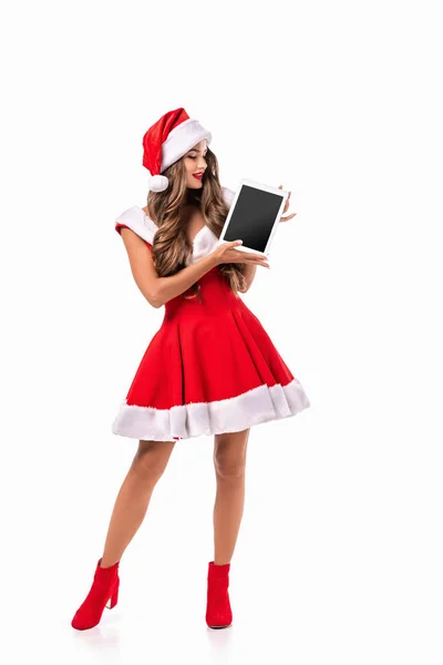 迷人的女孩在圣诞老人的服装呈现数字平板 孤立的白色 — 图库照片
