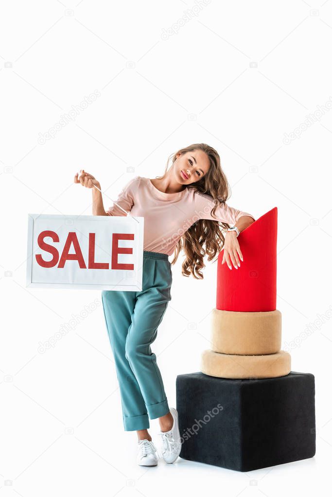 beautiful woman holding sale symbol near big red lipstick, makeup concept, isolated on white 