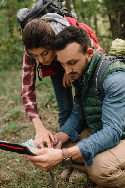 couple of travelers with map got lost in woods