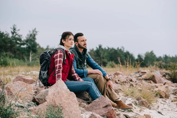 Fundersam Man Och Kvinna Med Ryggsäckar Vilar Stenar Sandstrand — Stockfoto