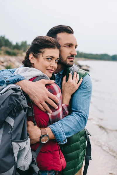 Dva Turisté Batohy Objímání Písečné Pláži — Stock fotografie