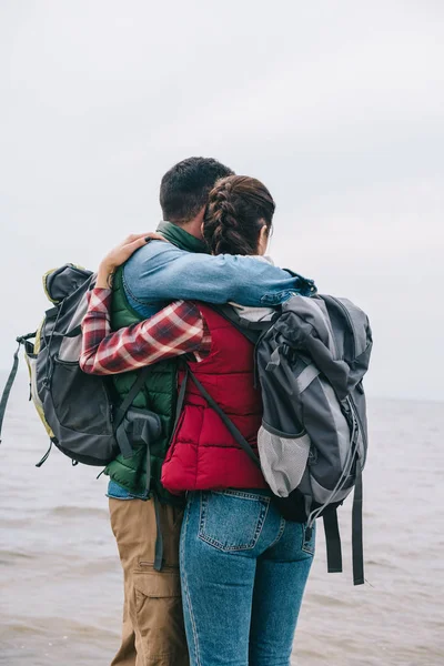 Couple Hikers Backpacks Hugging Looking Sea — Free Stock Photo