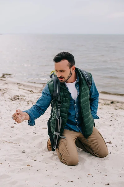 Mann Mit Rucksack Schüttet Sand Auf Strand — Stockfoto