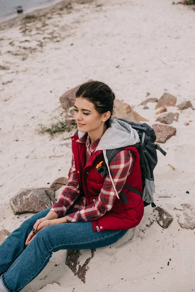 Зайнята Жінка Рюкзаком Відпочиває Каменях Піщаному Пляжі — Безкоштовне стокове фото