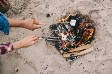Kavurma marshmallow kumlu plajda kamp ateşi üzerinde çift doz kırpılmış