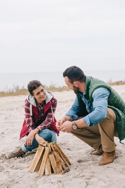 Couple Souriant Faisant Feu Camp Sur Plage Sable — Photo gratuite