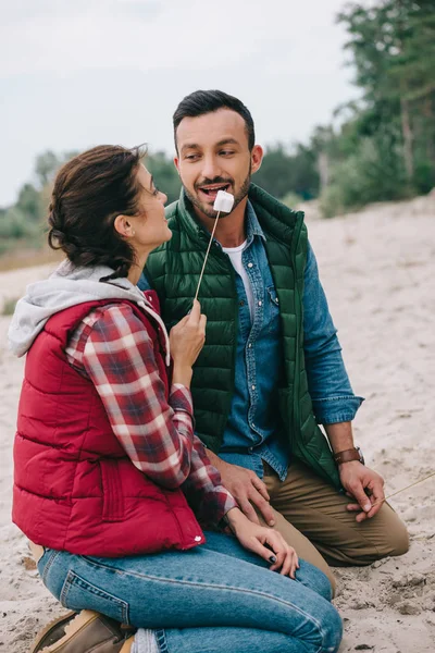 Woman Feeding Husband Marshmallow Sandy Beach — Free Stock Photo