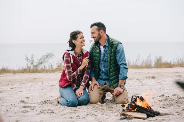 Woman Feeding Husband Marshmallow Campfire Sandy Beach — Free Stock Photo