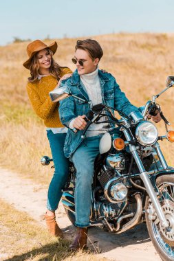 retro motosiklet kırsal çayır üzerinde oturan genç mutlu çift