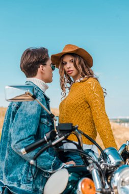 güzel kız kameraya bakarak süre retro motosiklet üzerinde oturan erkek