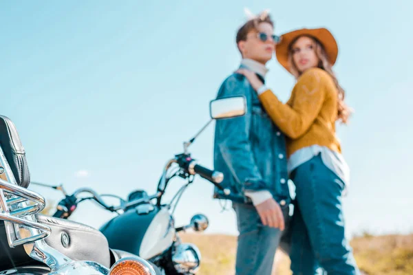 Paar Steht Neben Retro Motorrad Auf Wiese — kostenloses Stockfoto