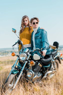 Erkek sarılma ve retro motosiklet üzerinde oturan genç kız