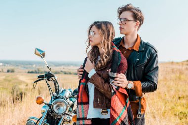 Çift uzağa bakarak ve retro motosiklet duran gözlük