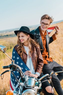 mutlu çift vintage motosiklet, bağımsızlık günü kavramı üzerinde oturan Amerikan bayrağı ile  