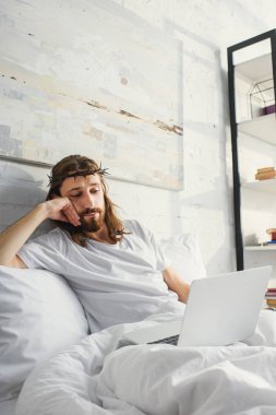 şüpheci İsa dizüstü yatakta evde sabah zaman sırasında kullanma.