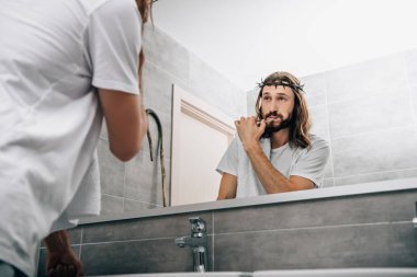 diş fırçalama ve banyo kendi yansıması bakarak omuz üzerinde havlu ile İsa'nın kısmi görünümü 