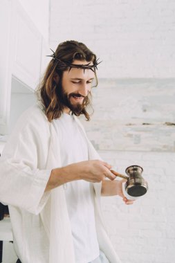 evde sabah zaman sırasında mutfakta bardağa İsa dökerek kahve cezve gülümseyen 