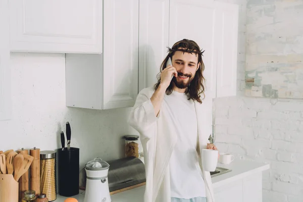 Smiling Jesus Crown Thorns Standing Cup Coffee Talking Smartphone Kitchen — Stock Photo, Image