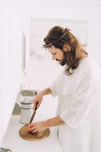 Utsikt Jesus Som Skjærer Oransje Med Kniv Treplanke Kjøkkenet Hjemme – royaltyfritt gratis stockfoto