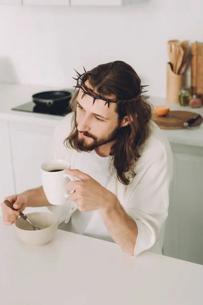 high angle view of Jesus eating corn flakes and drinking coffee on breakfast in kitchen at home