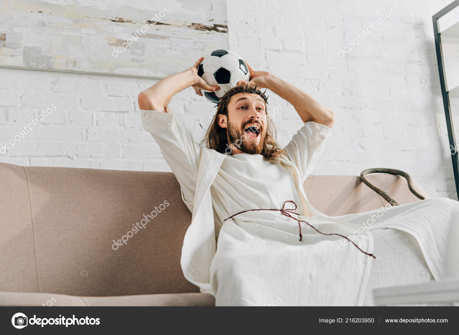 Um garoto segurando a velha bola de futebol antes de começar um jogo de  futebol