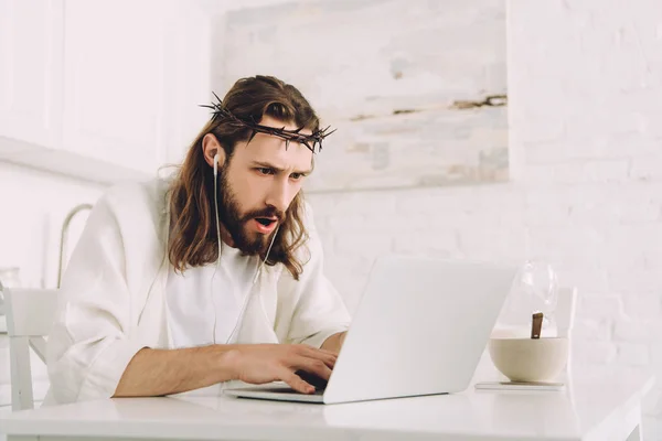 Emotionaler Jesus Dornenkrone Und Kopfhörer Mit Laptop Tisch Der Heimischen — kostenloses Stockfoto