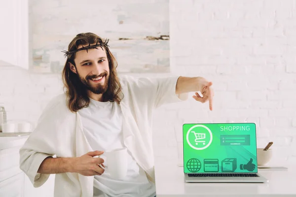 Happy Jesus Holding Cup Coffee Pointing Laptop Shopping Webiste Kitchen — Stock Photo, Image