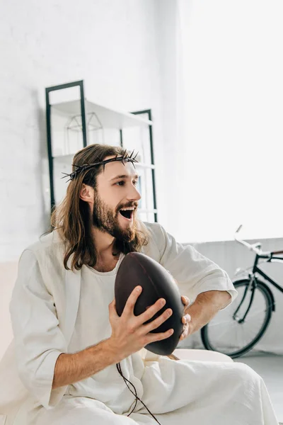 Боковой Вид Счастливого Иисуса Терновом Венце Держащего Мяч Смотрящего Регби — Бесплатное стоковое фото