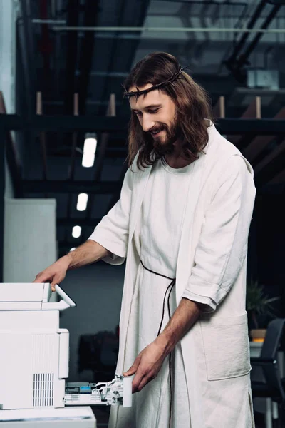 在现代办公室用复印机在荆棘和长袍王冠上快乐的耶稣 — 免费的图库照片