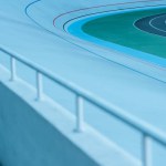 Close-up view of white railing and empty velodrome, urban background