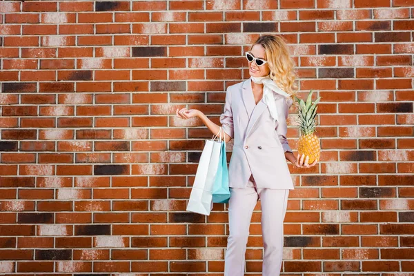 Beautiful Young Woman Pineapple Shopping Bags Standing Front Brick Wall — Free Stock Photo