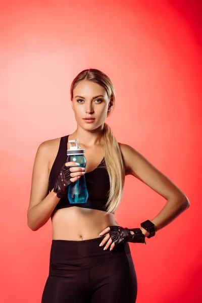 Atractiva Deportista Sosteniendo Botella Deporte Con Agua Mirando Cámara Aislada — Foto de Stock