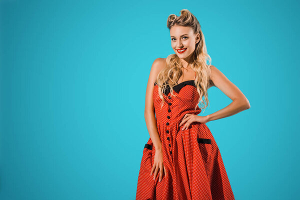 портрет красивой улыбающейся женщины в стиле ретро, позирующей изолированно на голубом

